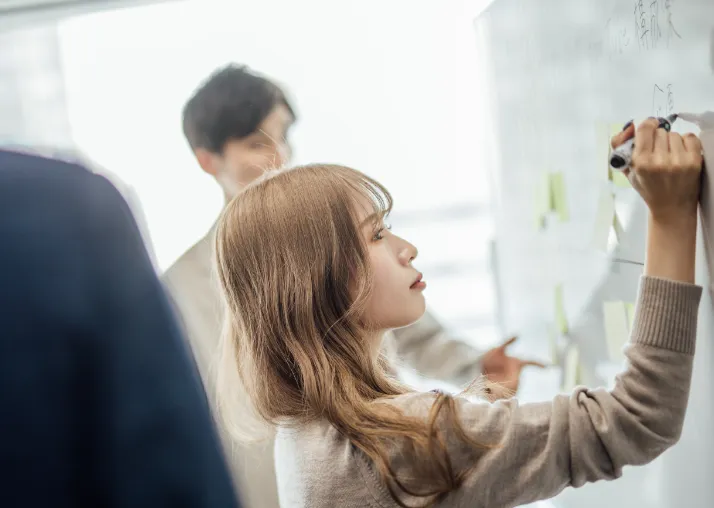 女性がホワイトボードにまとめている画像